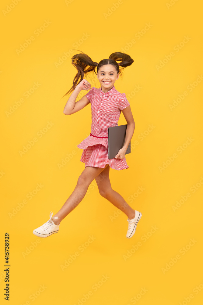 happy kid girl jumping with laptop go successful online shopping, sale