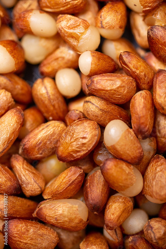 Background of peeled pine nuts from Siberia, milky color with a yellow dry skin. 
