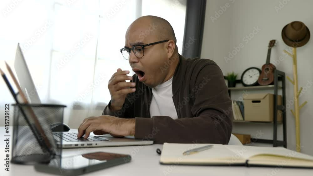 Tired businessman working with laptop. He covered his mouth with his hand and yawned. He is very sleepy. He work from home.
Tired businessman working with laptop. He covered his mouth with his hand and yawned. He is very sleepy. He work from home.