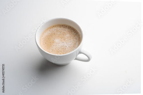 White cup of coffee in soft light isolated on a white background. Cappuccino coffee. 