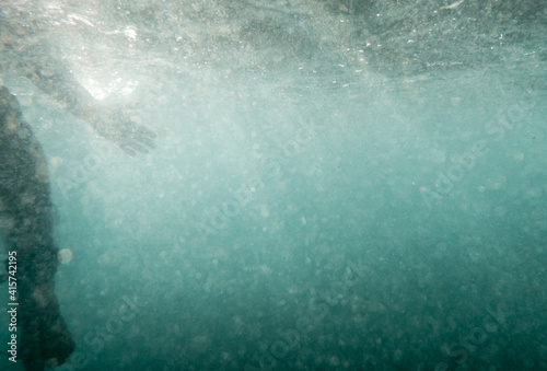 Underwater View of a Surfer Sitting on the Board whit Light Coming Through the Water.Sport Activity.Narrabeen beach,Sydney,Australia.