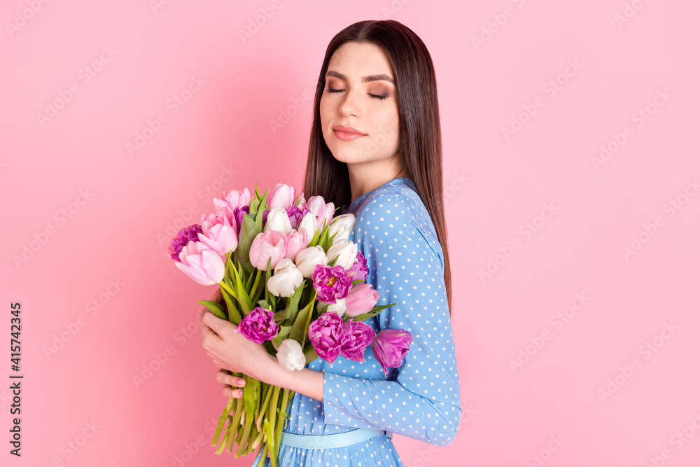 Photo of young beautiful lovely dreamy good mood girl smell bouquet flowers isolated on pink color background Photo of young beautiful lovely dreamy good mood girl smell bouquet flowers isolated on pink color background