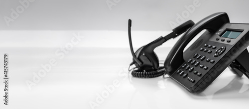 close up telephone devices with copy space background at office desk for customer service support, call center concept