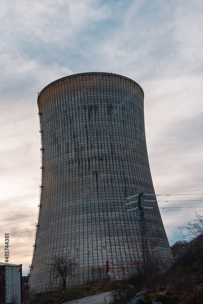 cooling tower of a thermoelectric plant in the process of dismantling near a town