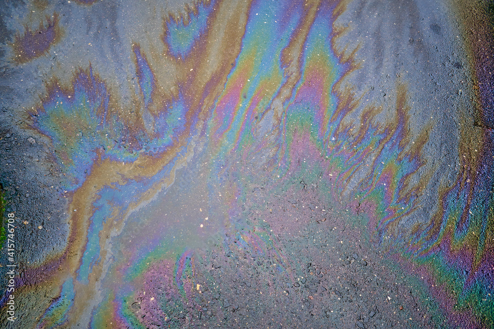 A circular rainbow gasoline stain on the asphalt