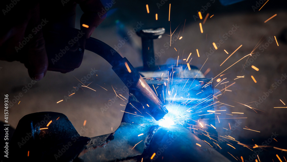 Welding of steel, sparking, not wearing gloves, light colored like fireworks. Welding of steel, sparking, not wearing gloves, light colored like fireworks.
