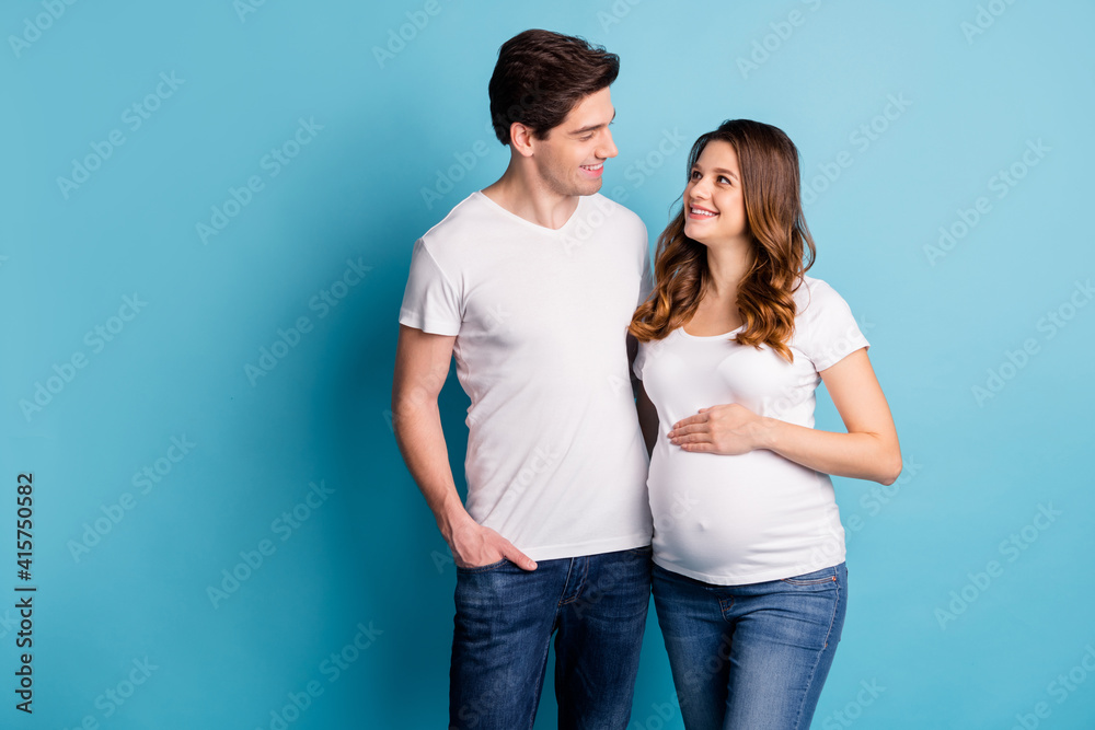 Photo of charming cheerful attractive sweet pretty couple expecting child arm hand belly isolated blue color background Photo of charming cheerful attractive sweet pretty couple expecting child arm hand belly isolated blue color background
