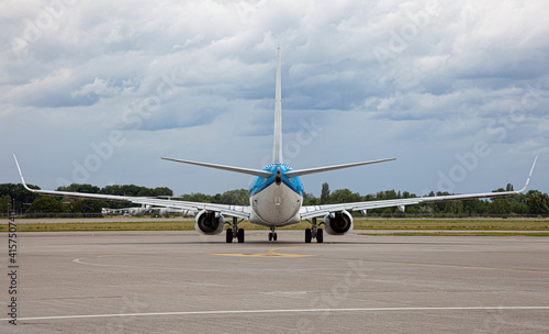 Passanger plane lands. Blue airplane on the platform of Airport. Runway. Landing aircraft.