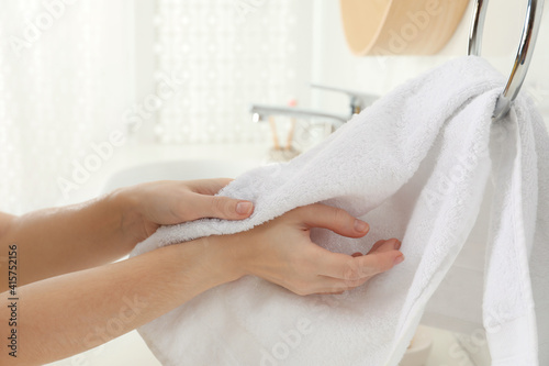 Woman wiping hands with towel in bathroom, closeup