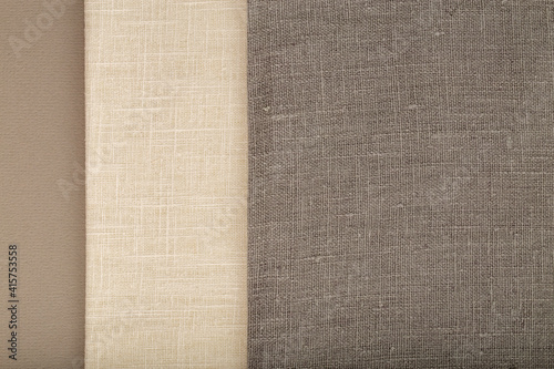 Flat linen fabric on a grey textured surface - off-white and grey linen