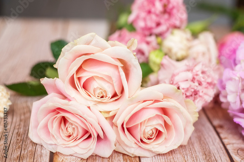 Close-up of different pastel roses in a bouquet on the table at the florist © галина шарапова