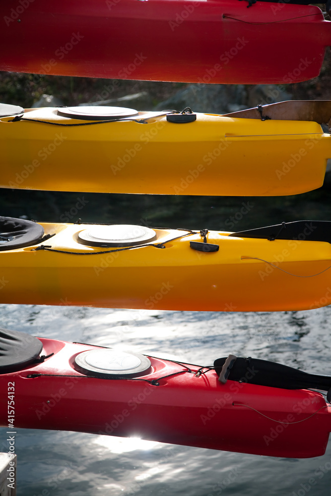 colorful sea kayaks stacked at a harbor