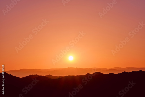 Rising sun over the mountain ridges as a background © kiwisoul