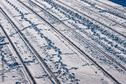 Railway track in winter. Snow covered railway lines, top view. Railway background. Train track texture, railway transportation background.