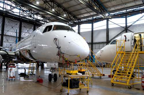 Aircraft is in the hangar for technical repair and maintenance. Aircraft diagnostics, storage, service. Plane. Ladders for mechanics