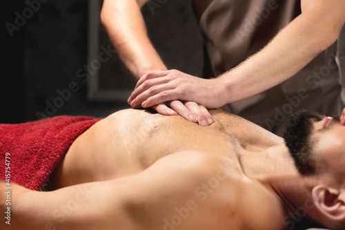 Sports massage. Breast massage. Physiotherapist doing a male breast massage to an athlete to a patient.