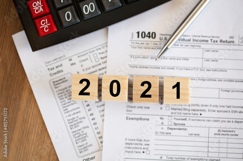 Tax time concepts. 1040 tax form on wooden table with pen and calculator