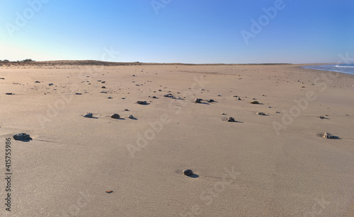 large view on sand of the beach and pebbles in the sand in  Altantic ocean