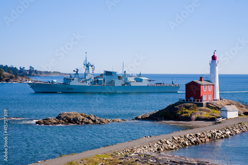 Fisgard Lighthouse with navy destroyer sailing past, Victoria, BC photo