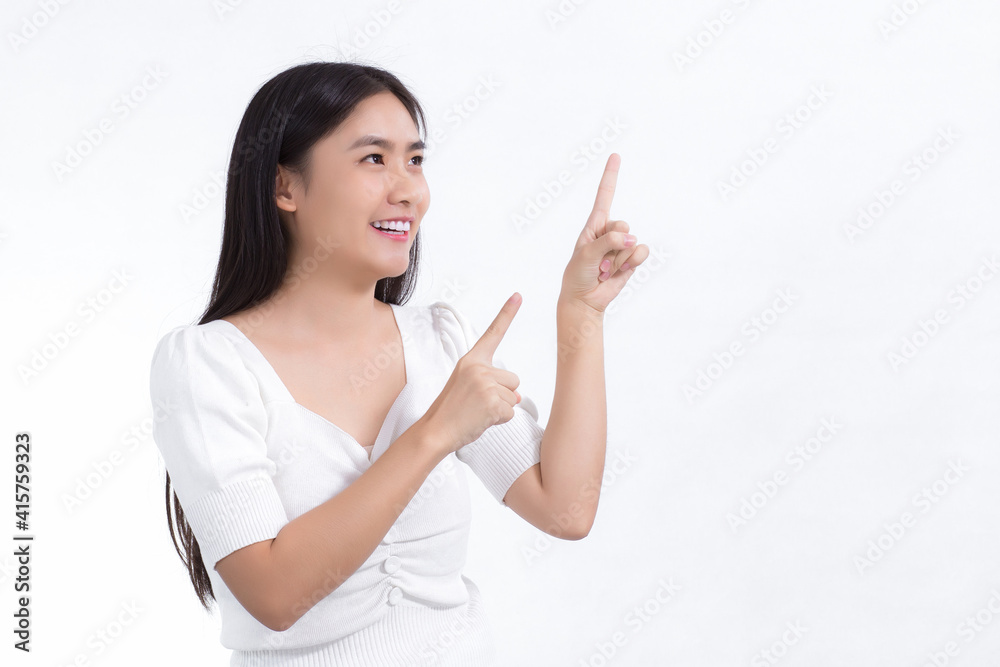 Asian woman in black long hair wears white shirt and shows point up to present something on white background. Asian woman in black long hair wears white shirt and shows point up to present something on white background.