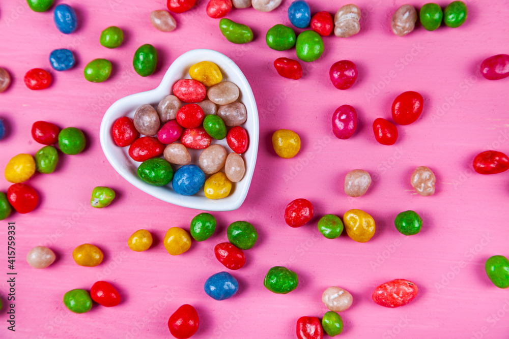 Multicolored candies in a plate in the shape of a heart Multicolored candies in a plate in the shape of a heart