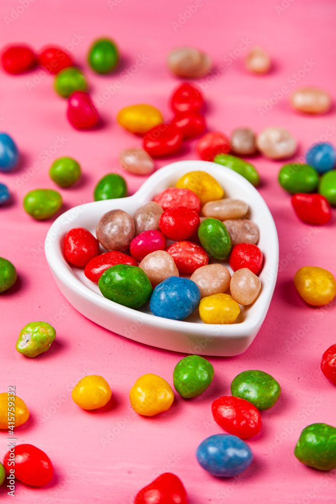 Multicolored candies in a plate in the shape of a heart Multicolored candies in a plate in the shape of a heart