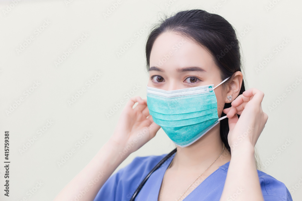 Asian female doctor is wearing medical face masks to protect from Coronavirus-19 (COVID-19) in healthcare and new normal concept. Asian female doctor is wearing medical face masks to protect from Coronavirus-19 (COVID-19) in healthcare and new normal concept.