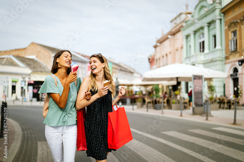 Shopping, sale, happy people and tourism concept. Smiling girls with shopping bags in ctiy © NDABCREATIVITY