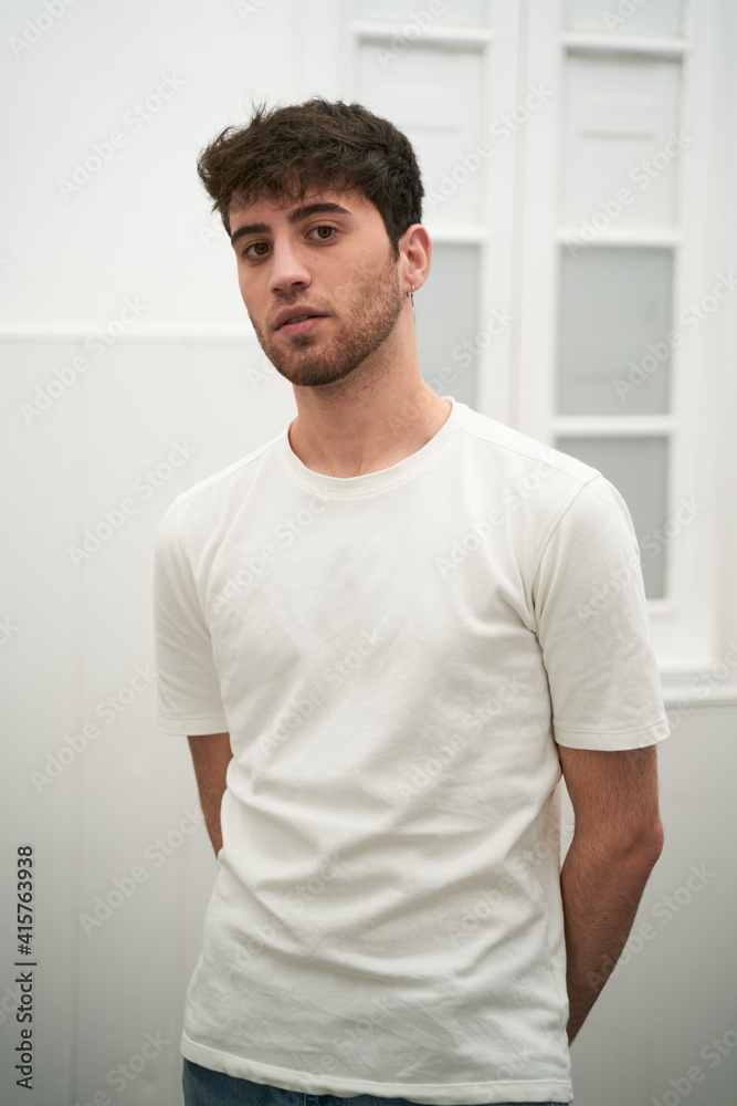 Fototapeta premium young Spanish boy stretching as the day begins in a brightly lit room