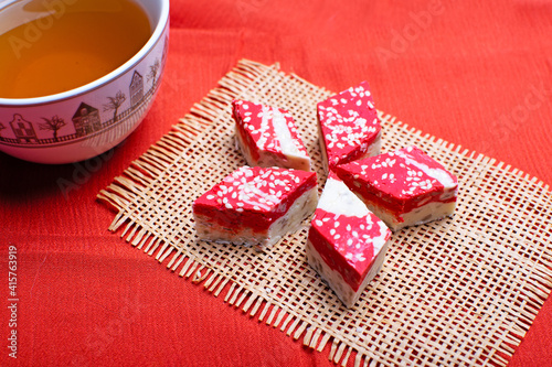 Pomegranate halva dessert slices on the table with a cup of tea.