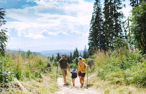 Family with small son hiking outdoors in summer nature. photo