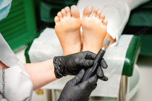 Chiropodist master prepares foot file machine before foot and toes clean treatment in a beauty salon