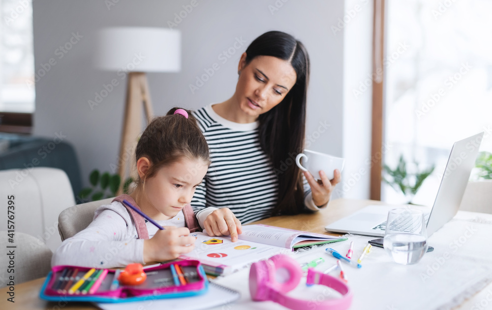 Mother with school girl indoors at home, distance learning and home office.