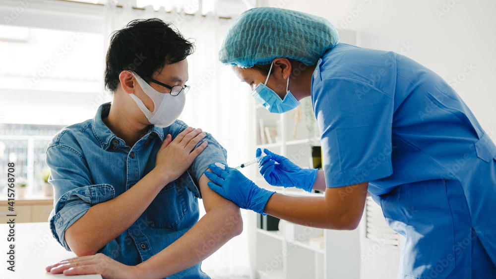 Fototapeta premium Young Asia lady nurse giving Covid-19 or flu antivirus vaccine shot to senior male patient wear face mask protection from virus disease at health clinic or hospital office. Vaccination concept.