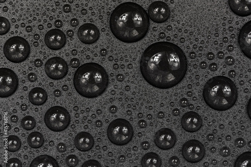 Water drops on black background texture. Dark backdrop glass covered with drops of water. gray bubbles in water