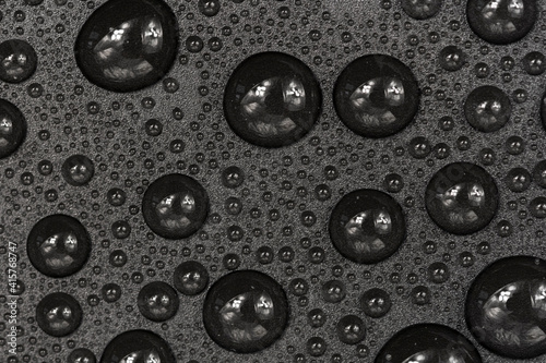 Water drops on black background texture. Dark backdrop glass covered with drops of water. gray bubbles in water