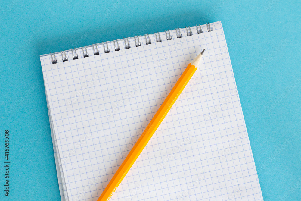 Student concept. Pen, notebook, pencil on a blue background Student concept. Pen, notebook, pencil on a blue background