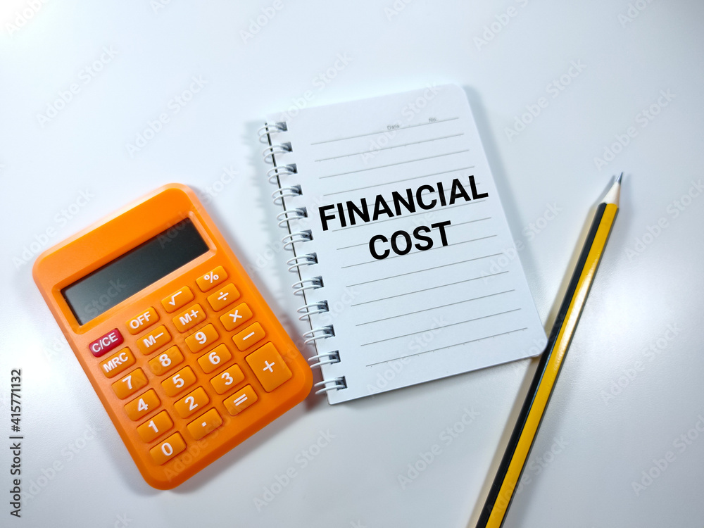 Selective focus.Word FINANCIAL COST on notebook with pen and calculator on white background.Business concept. Selective focus.Word FINANCIAL COST on notebook with pen and calculator on white background.Business concept.