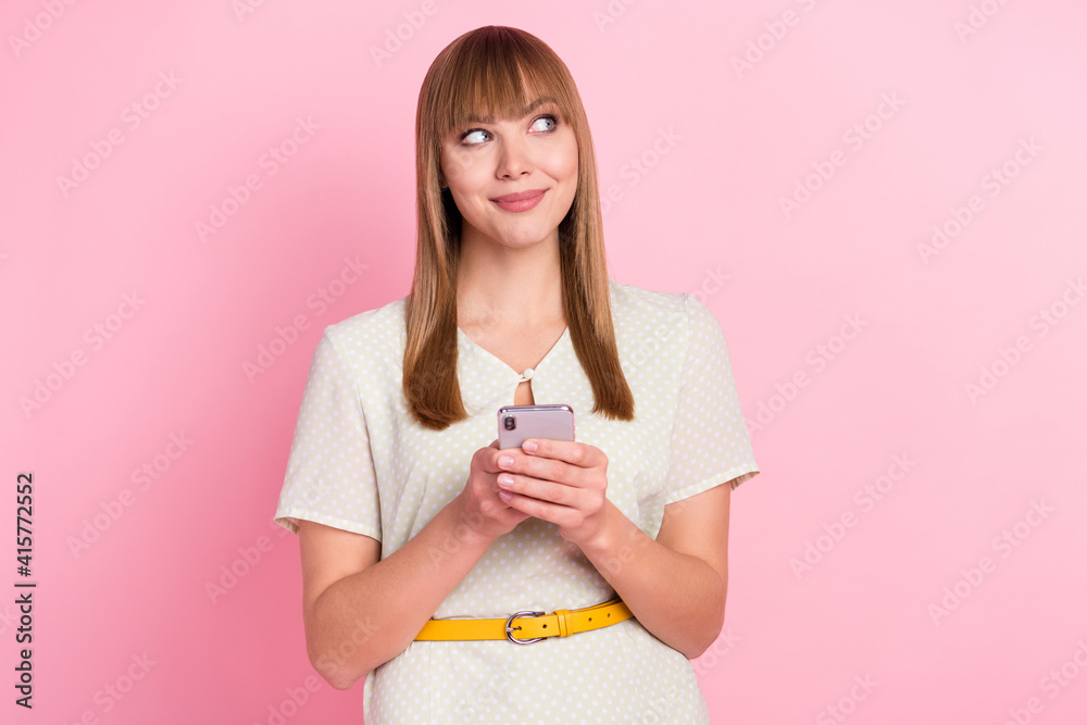 Portrait of pretty cheerful curious girl using device creating media comment smm isolated over pink pastel color background Portrait of pretty cheerful curious girl using device creating media comment smm isolated over pink pastel color background