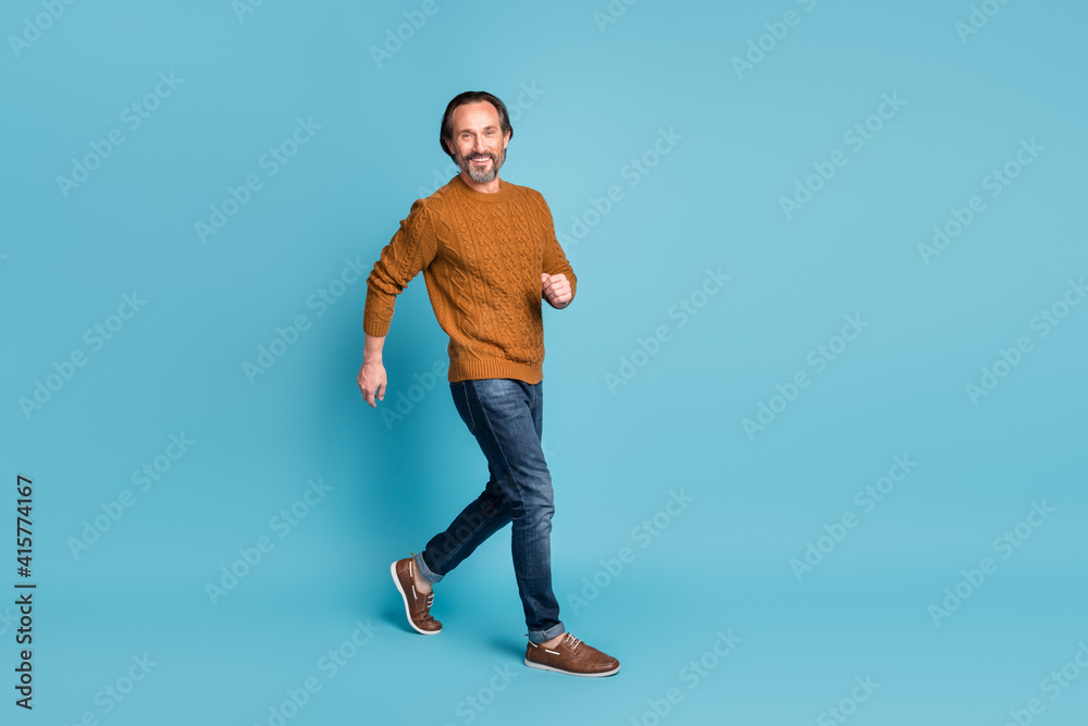 Full length body size photo middle-aged bearded man smiling going fast hurrying in casual outfit isolated on vibrant blue color background