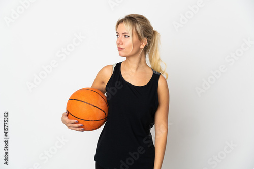 Young Russian woman playing basketball isolated on white background looking to the side
