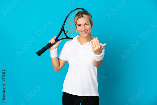 Young Russian woman isolated on blue background playing tennis and doing coming gesture © luismolinero