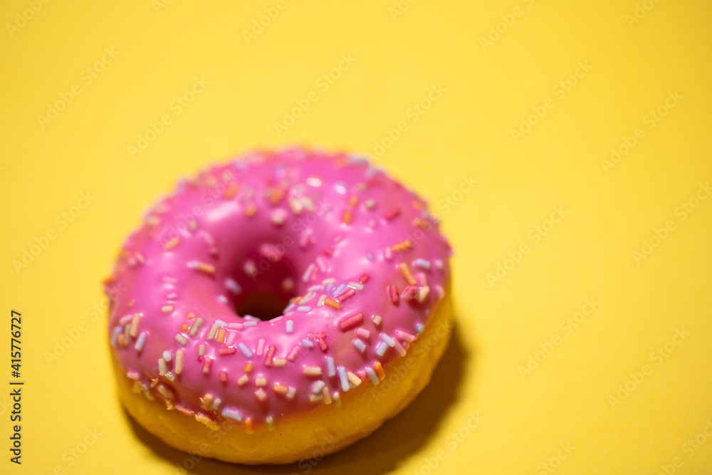Homemade circle donut with pink icing and rainbow sprinkles Homemade circle donut with pink icing and rainbow sprinkles