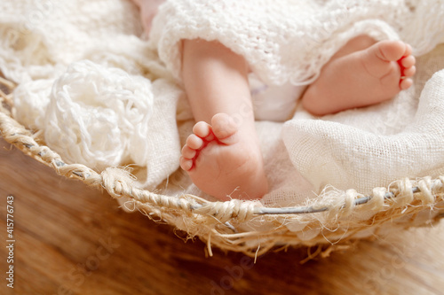 Newborn baby feet on creamy blanket. Maternity, family, birth concept.