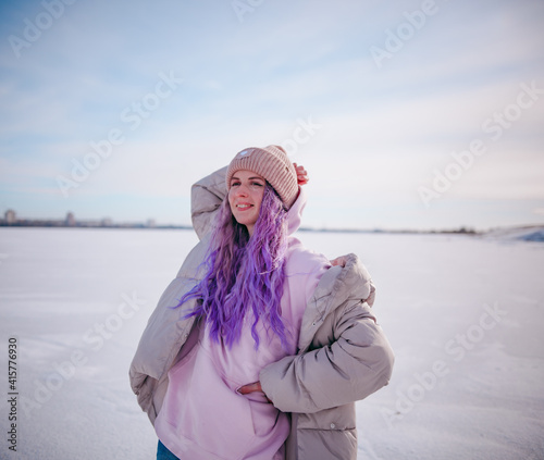 a girl with purple hair stands on a snow-covered lake