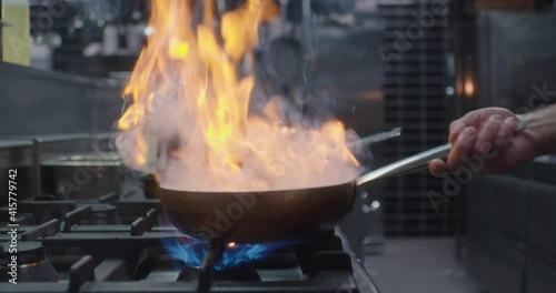 The cook is working with the pan