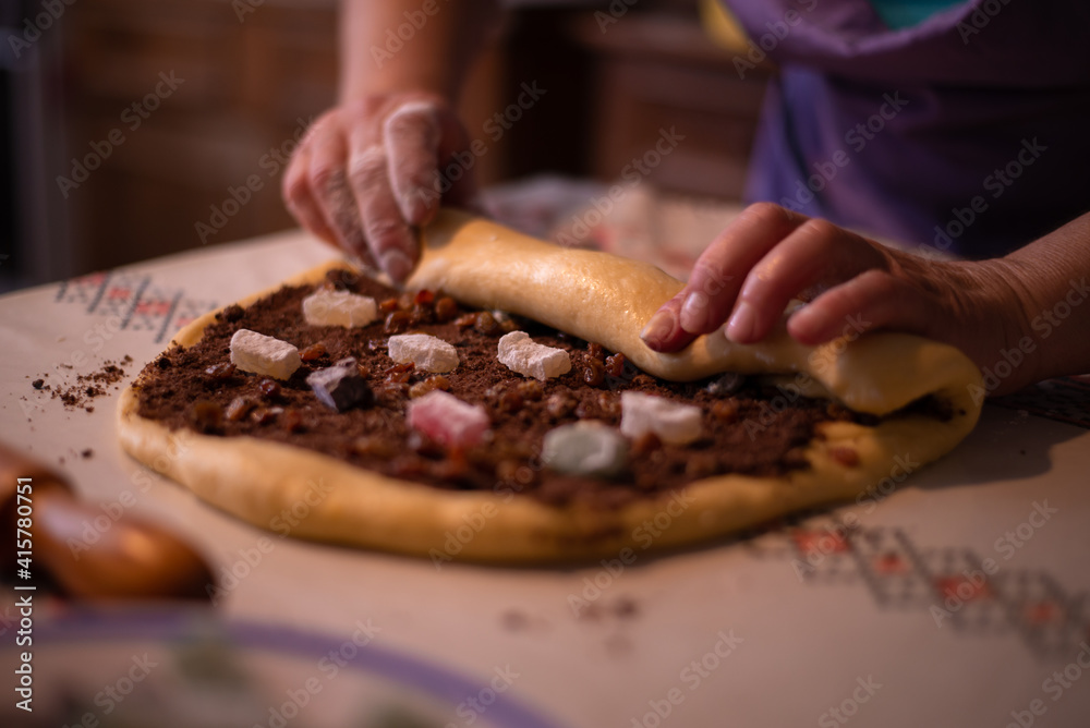 adding fillings to the cake as turkis delights, cocoa and nuts in the recipe of cozonac a traditional romanian preparation