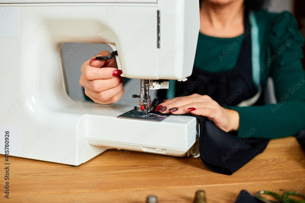 Step by step, 50-yers old woman sews clothes on sewing machine