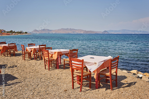 Greek beach with traditional blue tables and chairs © Ryzhkov Oleksandr