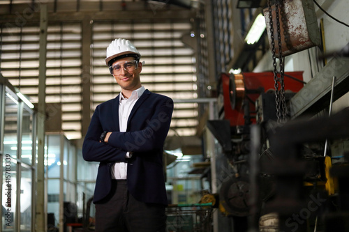 Portrait of Caucasian engineer manager standing inside mechanic factory with copy space for industrial style concept